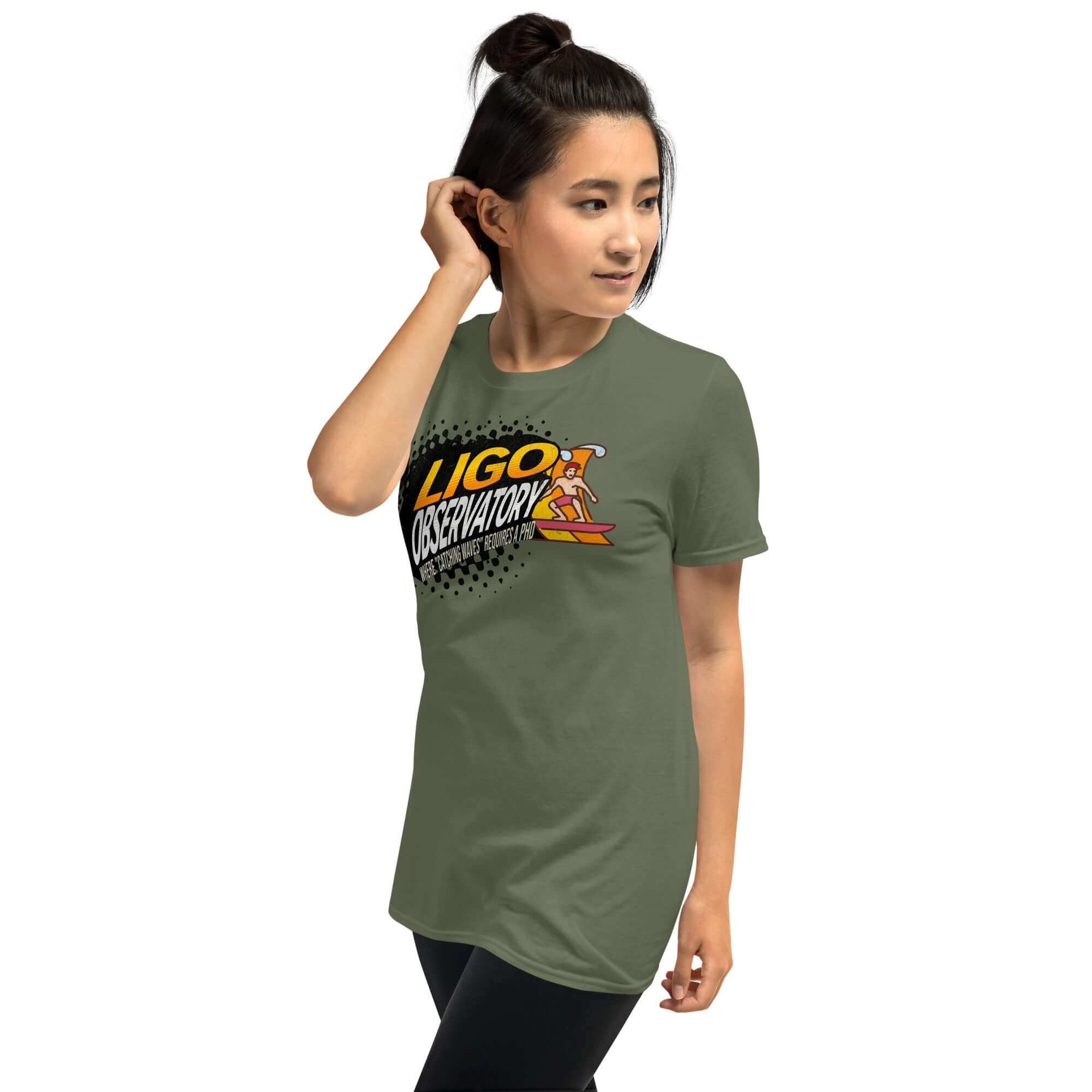 Woman wearing LIGO Observatory T-shirt with vibrant lettering on olive green, showcasing scientific exploration in style.