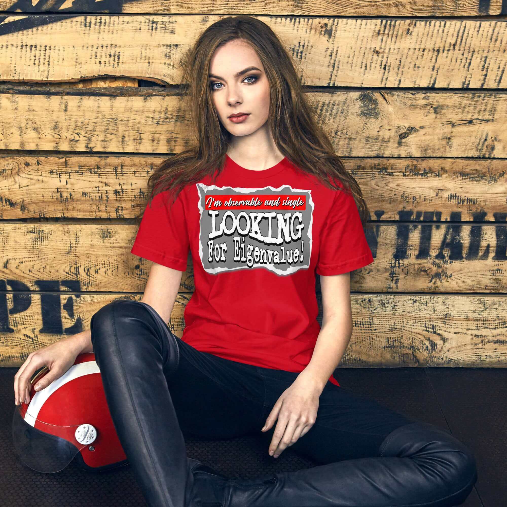 Woman in red t-shirt with 'Looking for Eigenvalue' text, sitting against a wooden background.