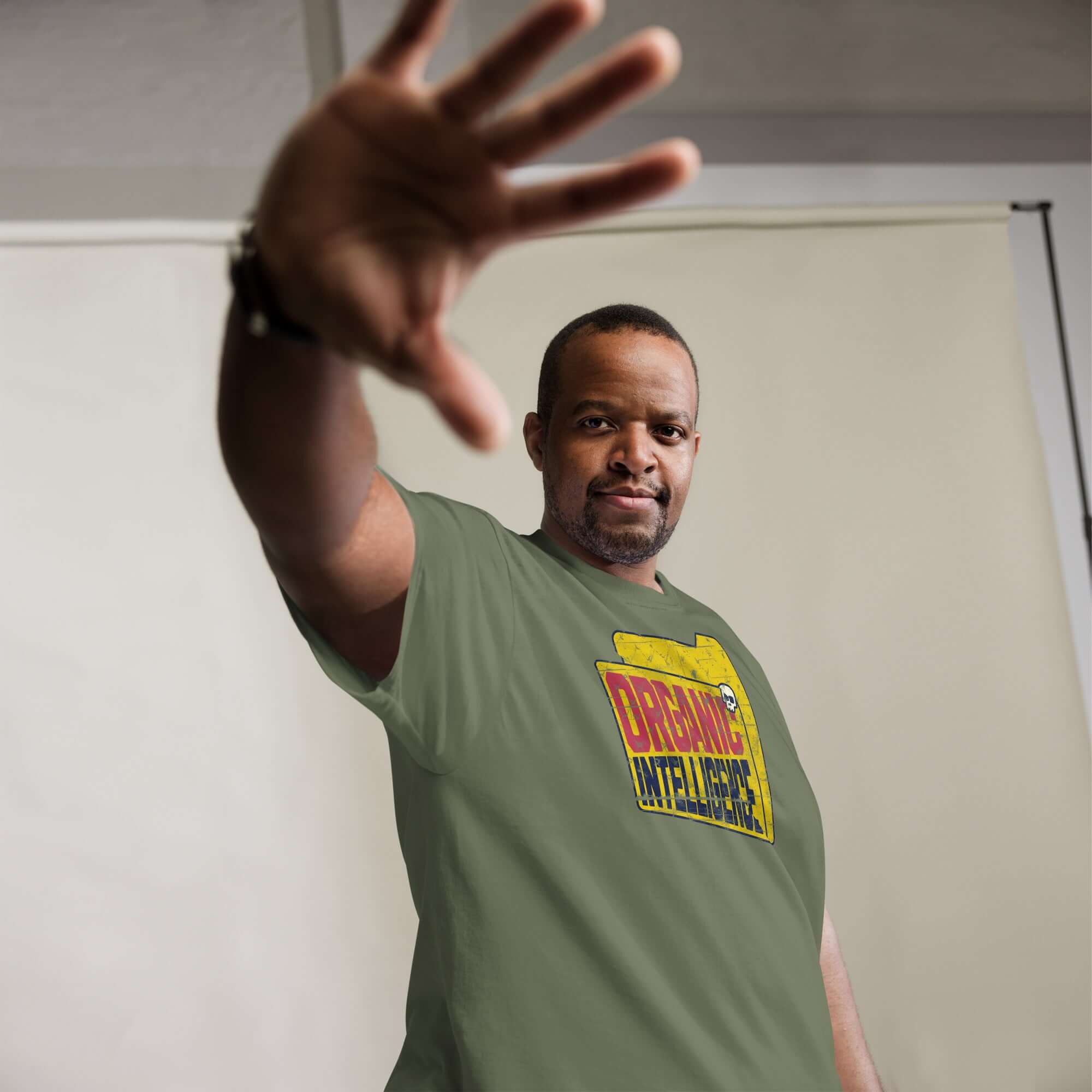 Man wearing Organic Intelligence Anti-AI Humor Tee with computer file icon, showcasing tech rebellion statement in green shirt.