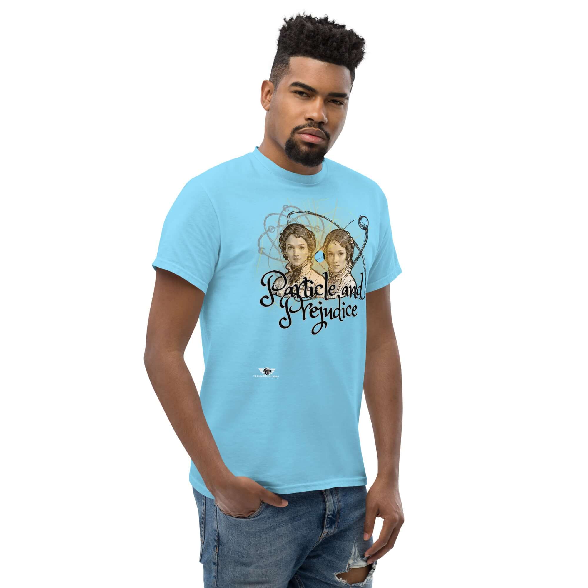 Model wearing blue 'Particle and Prejudice' t-shirt, featuring fusion of Regency romance and quantum physics design.