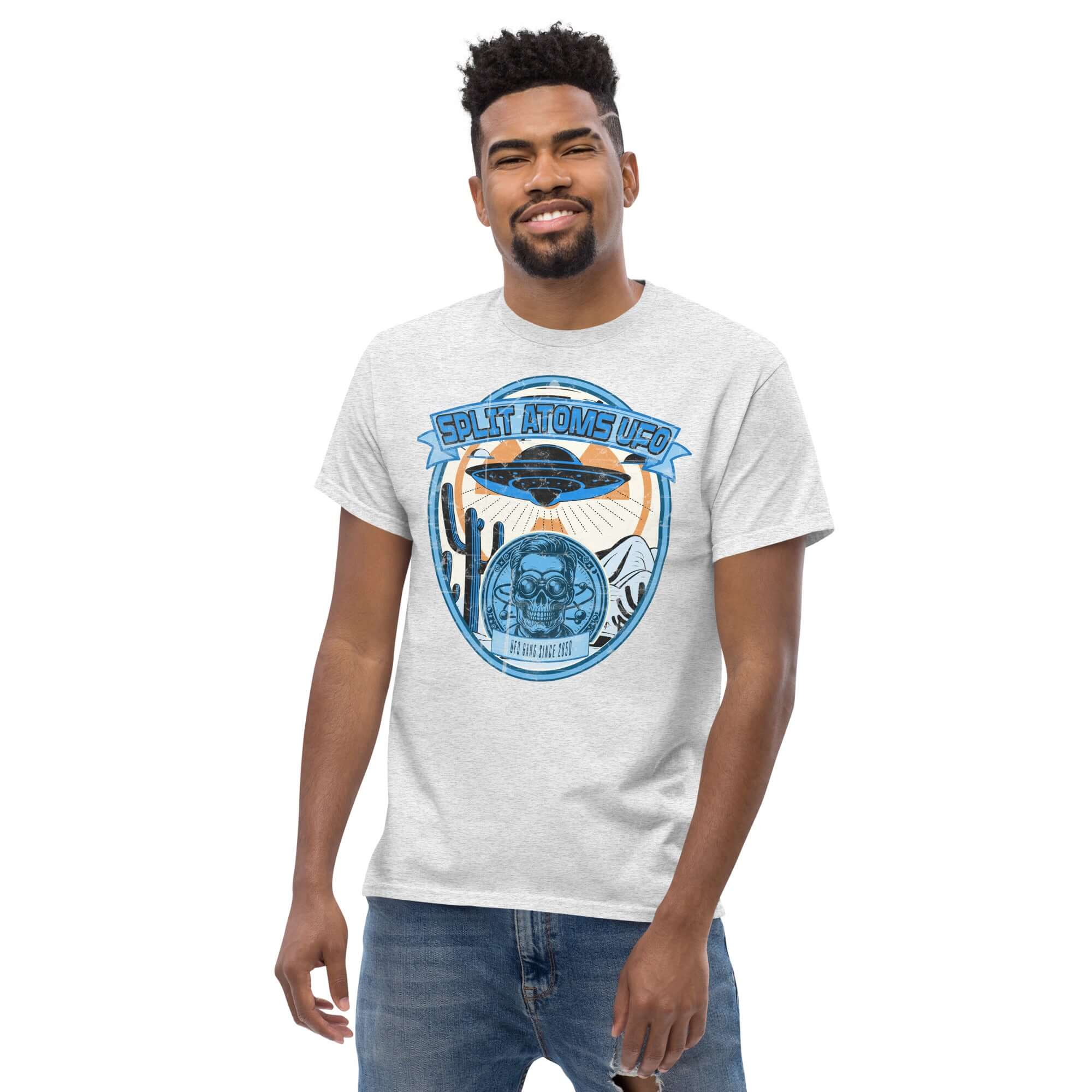 Man wearing Split Atoms UFO Gang T-Shirt with retro alien desert design, flying saucer graphic in Nevada-like setting.