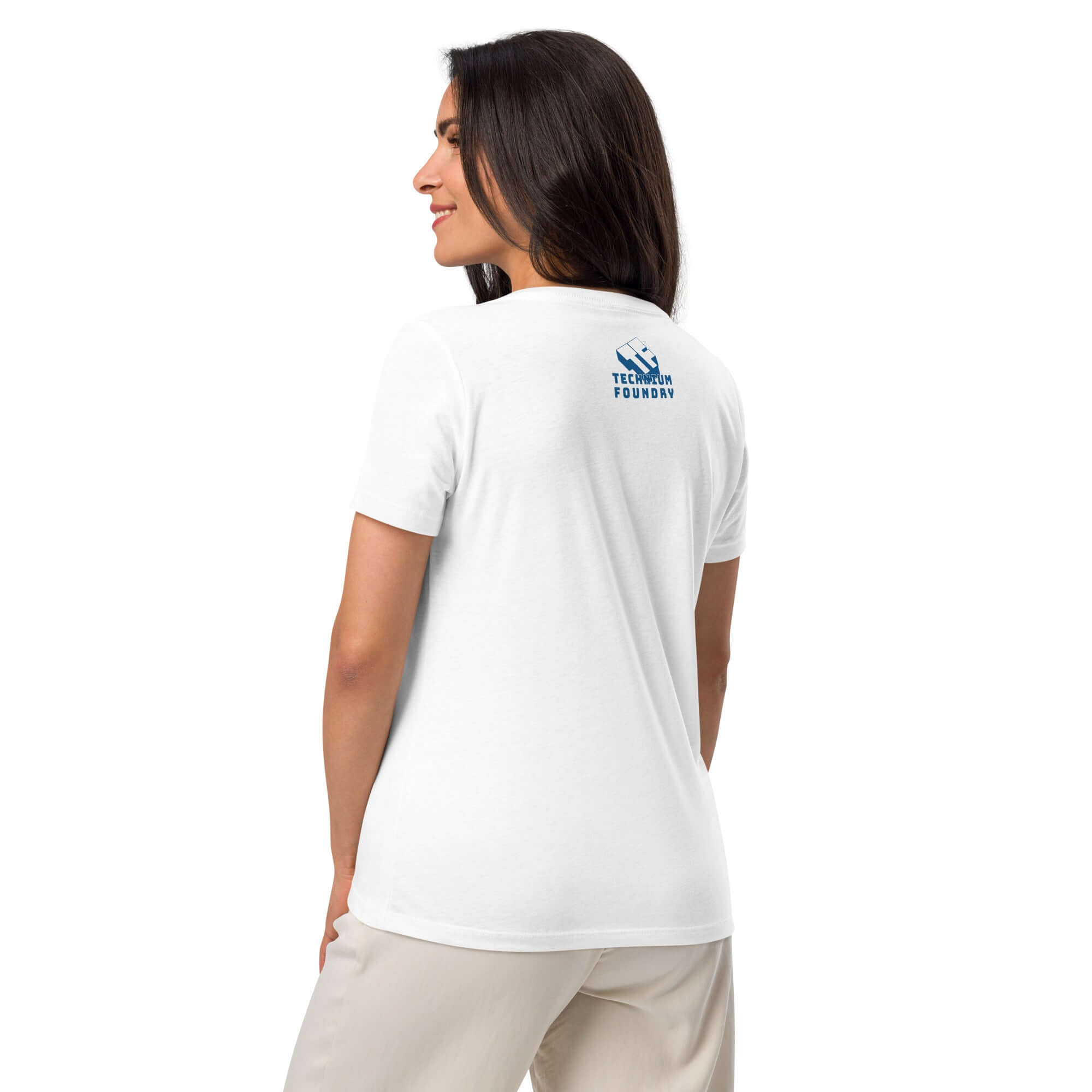 Woman wearing a white t-shirt with a small blue logo on the back, paired with beige pants, viewed from behind.