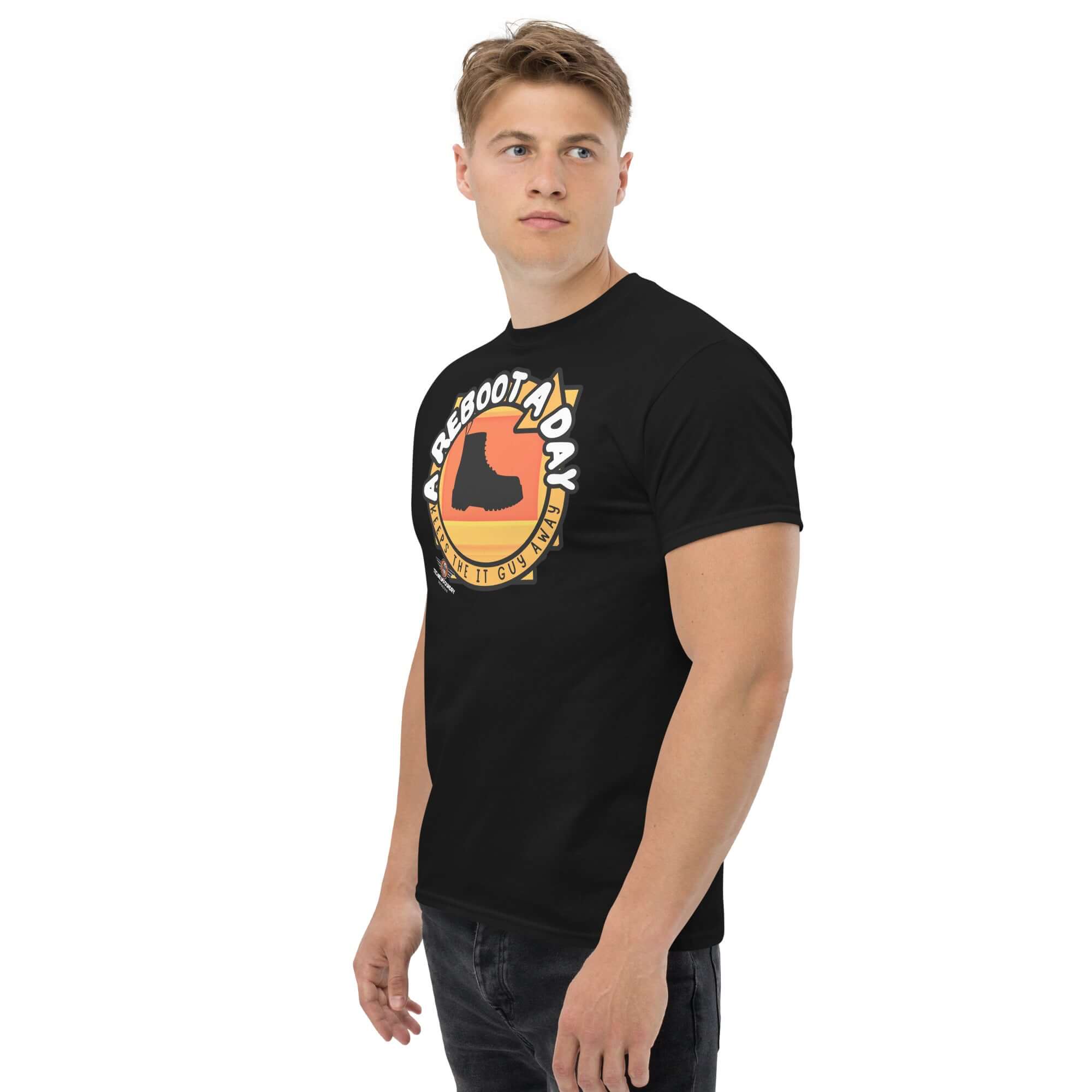 Man wearing 'A Reboot A Day' IT support humor t-shirt with tech boot design and sunset backdrop.