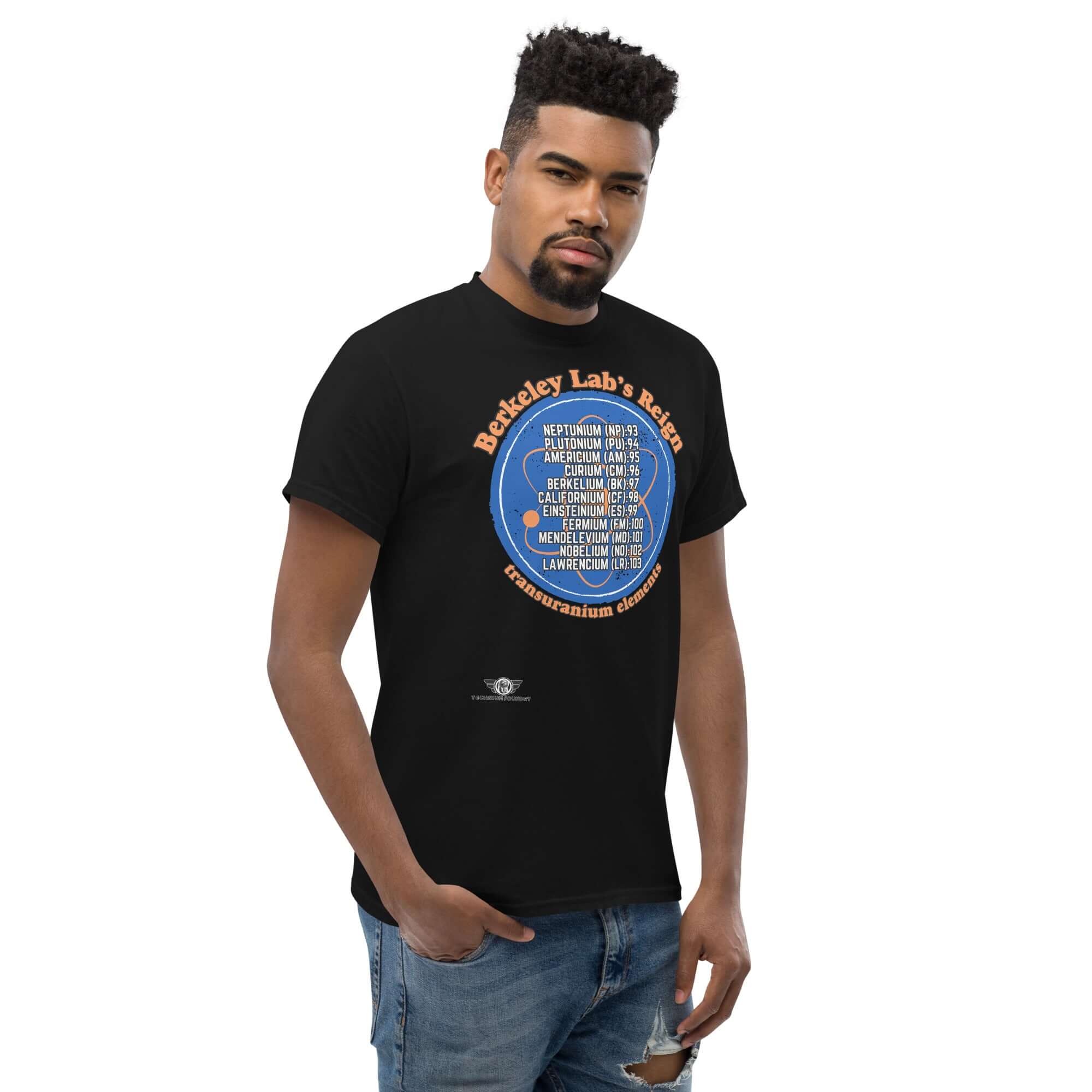 Man wearing Berkeley Lab's Reign Transuranium Elements T-Shirt showcasing atomic numbers 93-103 in a circular design on black fabric.
