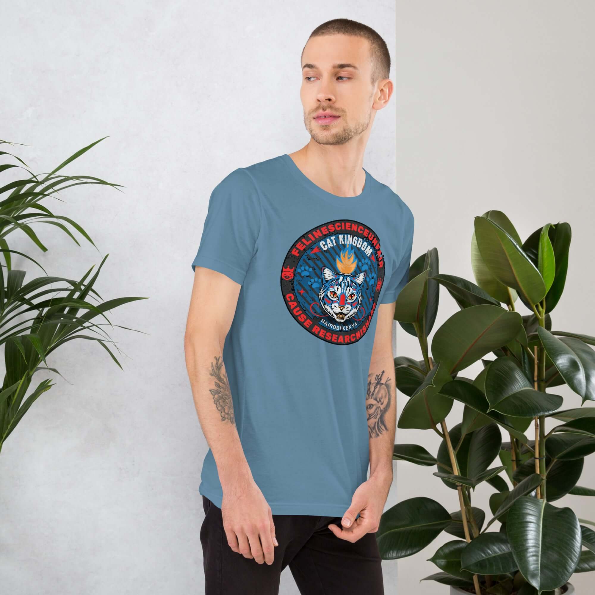 Feline Science Unit Cat Kingdom T-Shirt featuring wildcat design, worn by man near plants in Nairobi, Kenya.