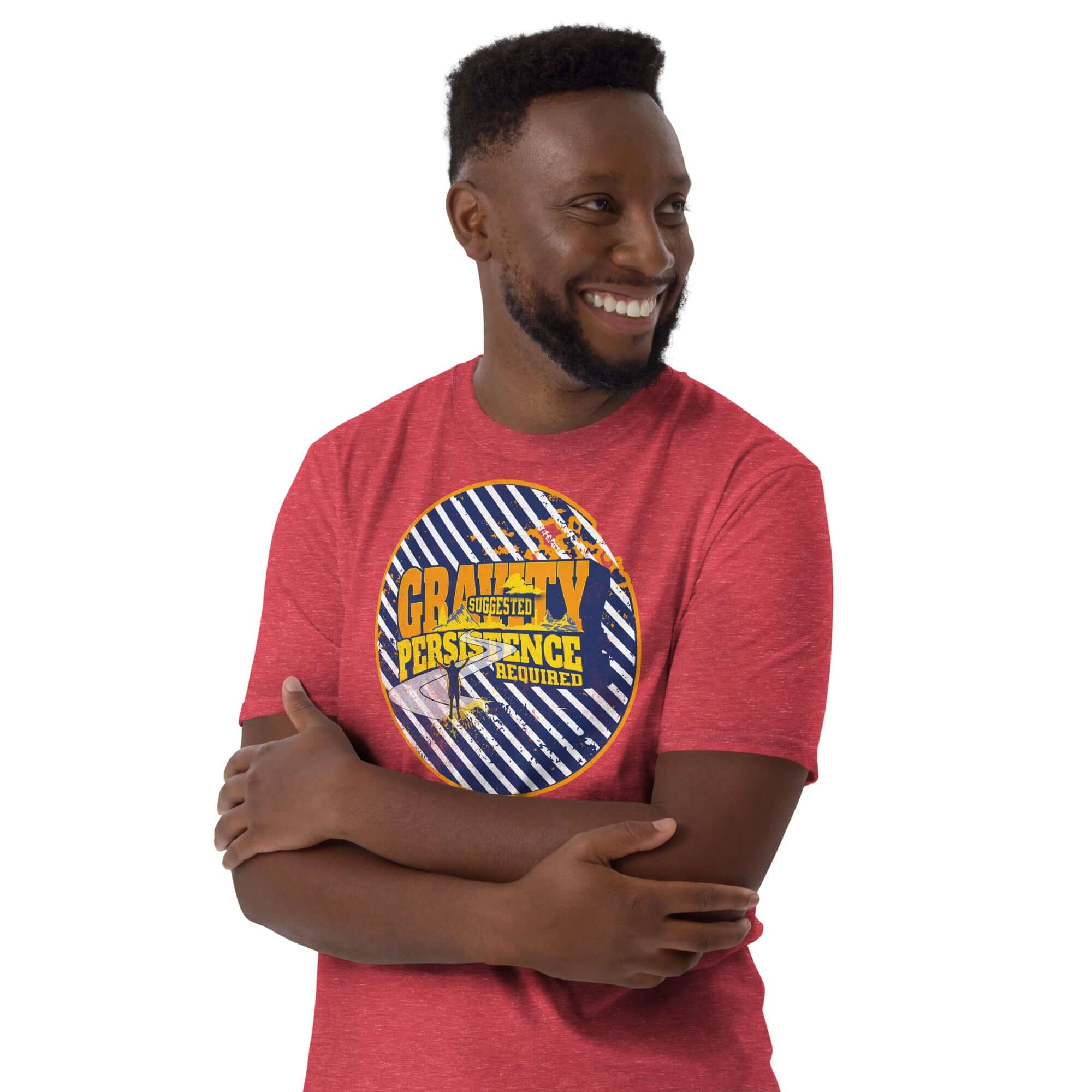 Man wearing "Gravity: Suggested. Persistence: Required." t-shirt with navy and yellow emblem on red background, expressing motivation and determination.