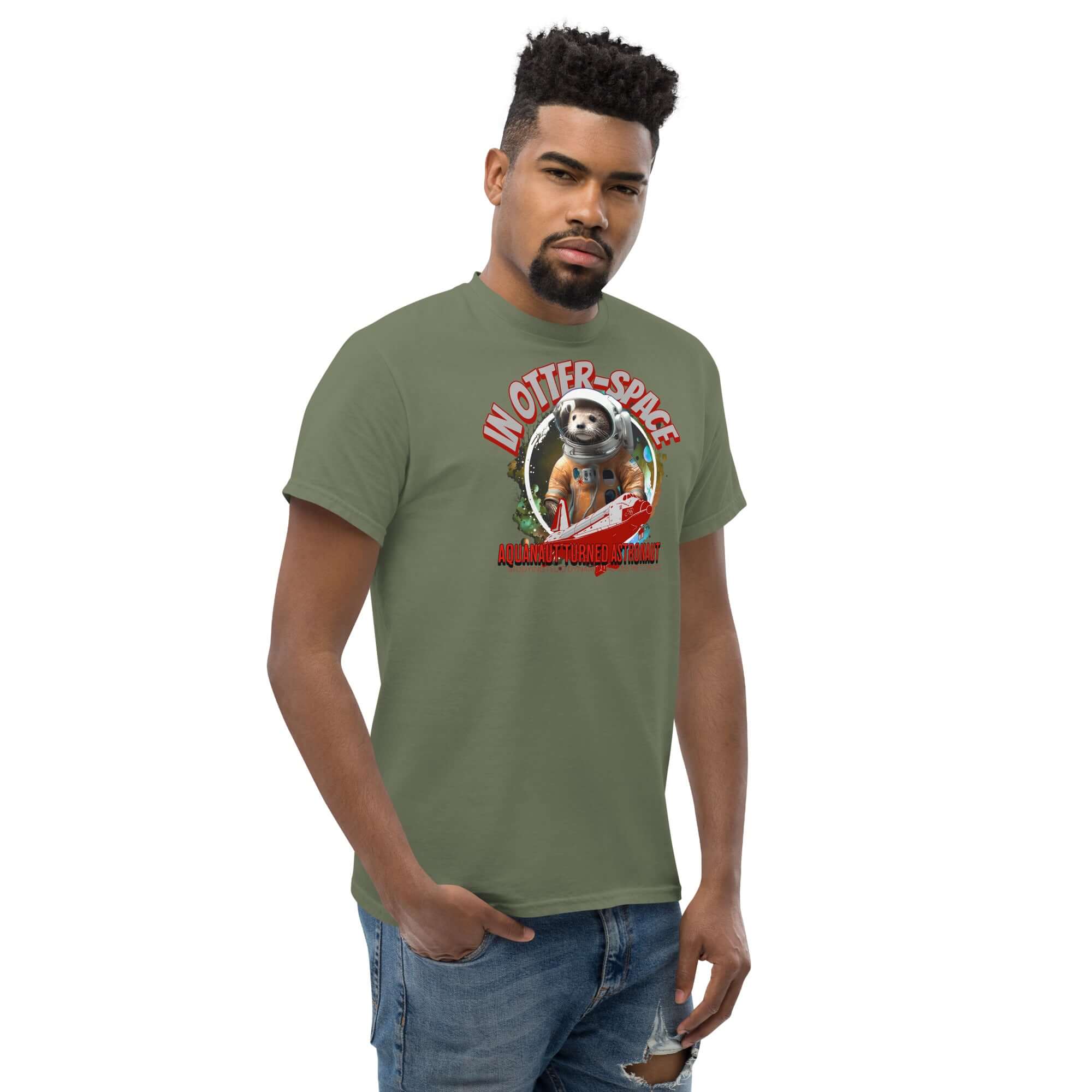 Man wearing 'In Otter Space: Aquanaut Turned Astronaut' t-shirt with otter in astronaut suit design, space shuttle, and cosmic background.