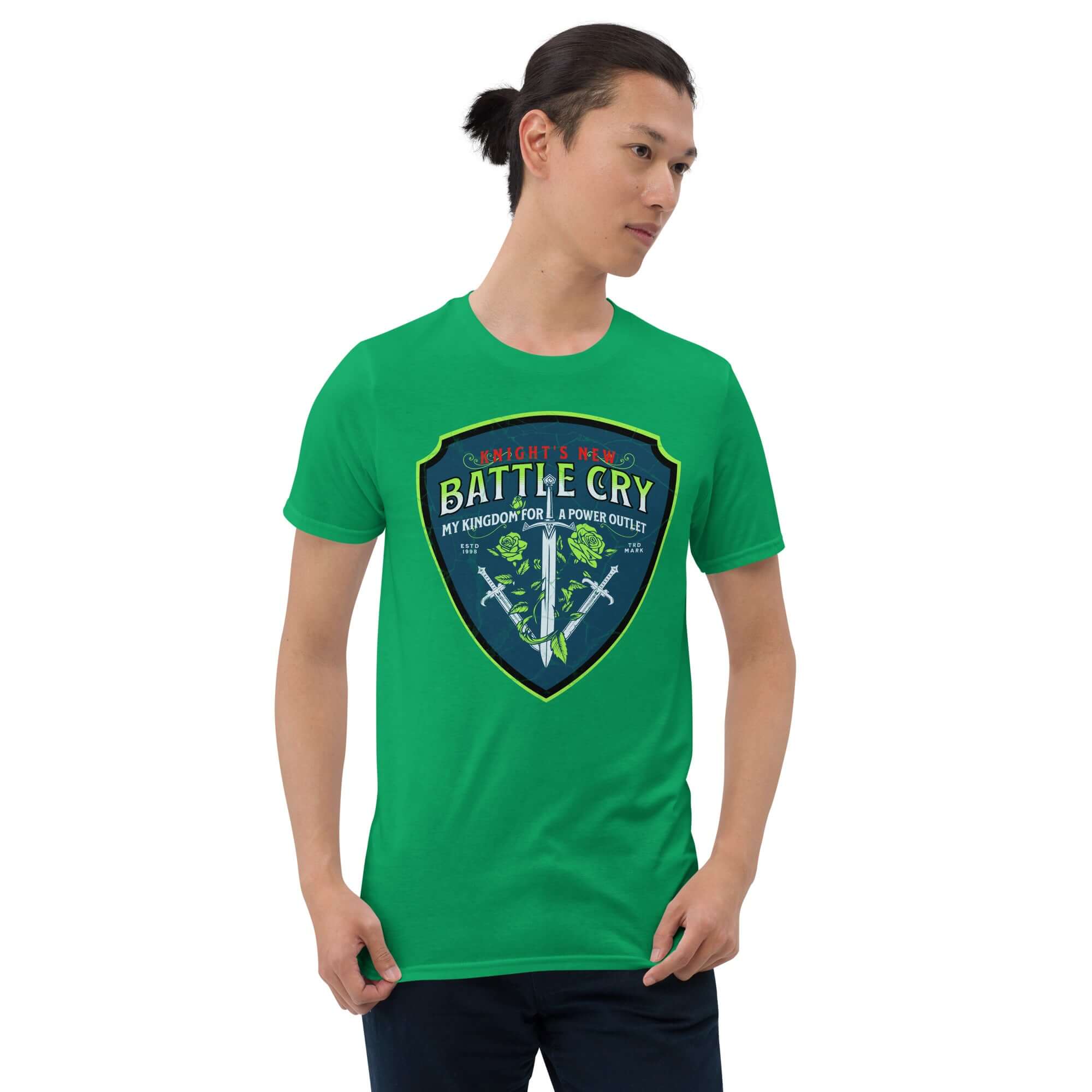 Man wearing green T-shirt featuring 'Knight's New Battle Cry: My Kingdom For A Power Outlet' medieval tech humor design with swords and roses.