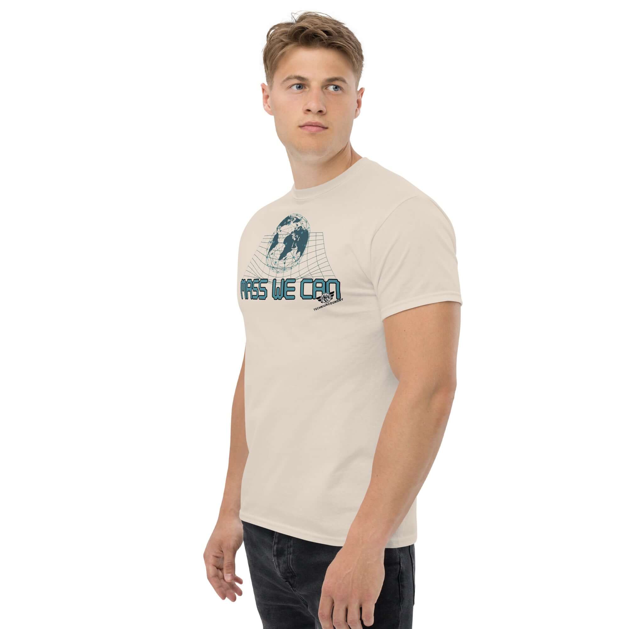 Man wearing "Mass We Can" t-shirt with space-time curvature design, inspired by Einstein's general relativity, in beige color.