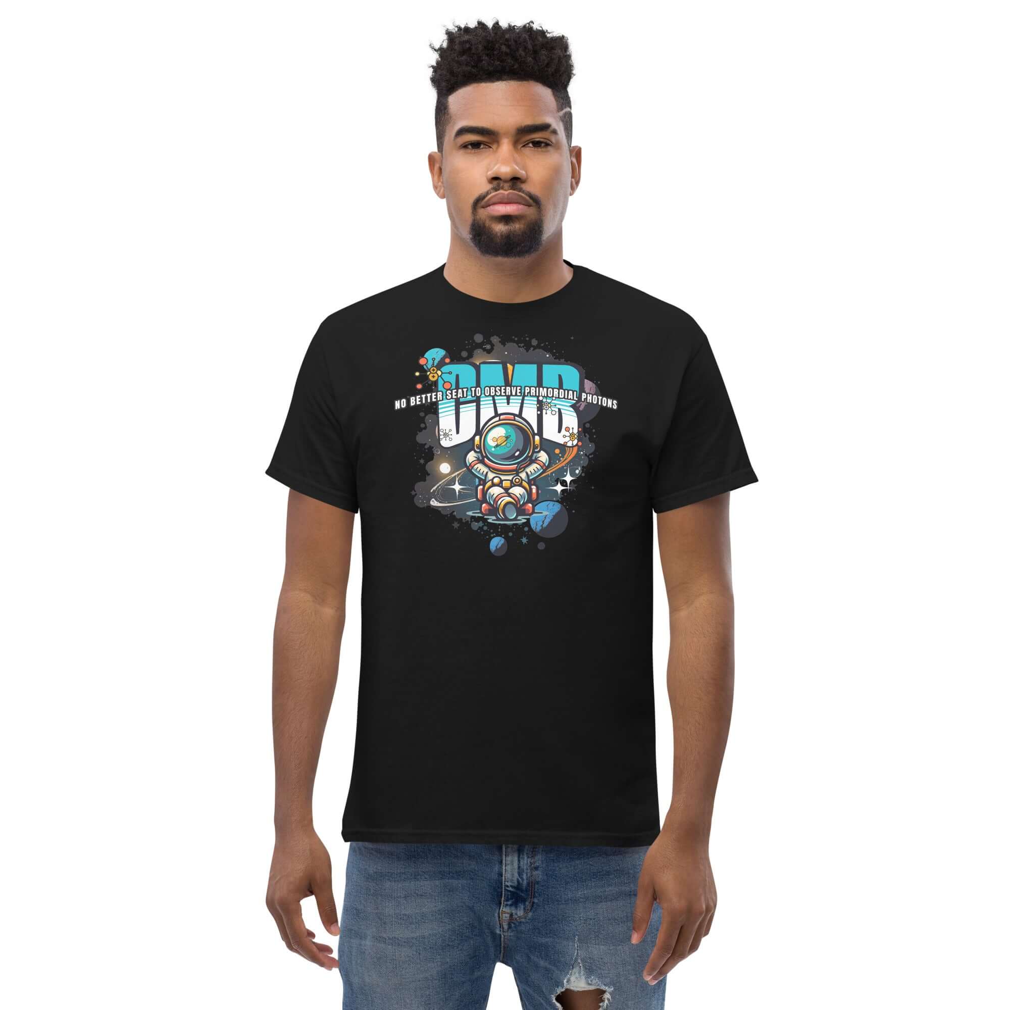 Man wearing a black "Primordial Photons" t-shirt featuring an astronaut in space with planets, graffiti text, and cosmic design.