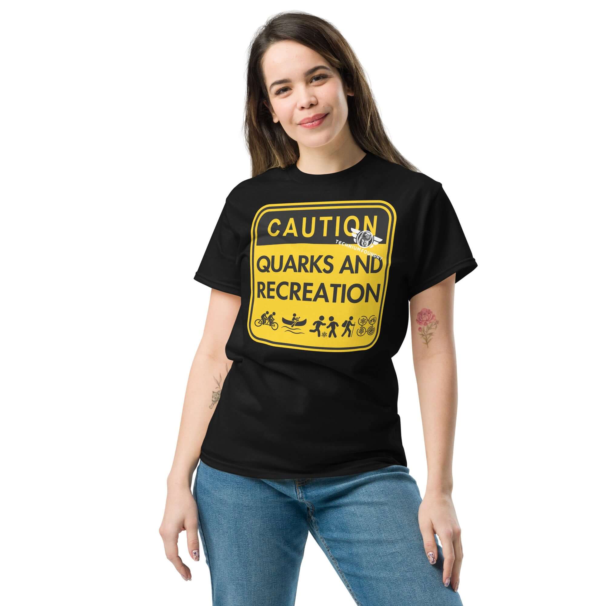 Woman wearing 'Quarks and Recreation' t-shirt with particle physics warning sign design, combining physics humor and outdoor adventure.