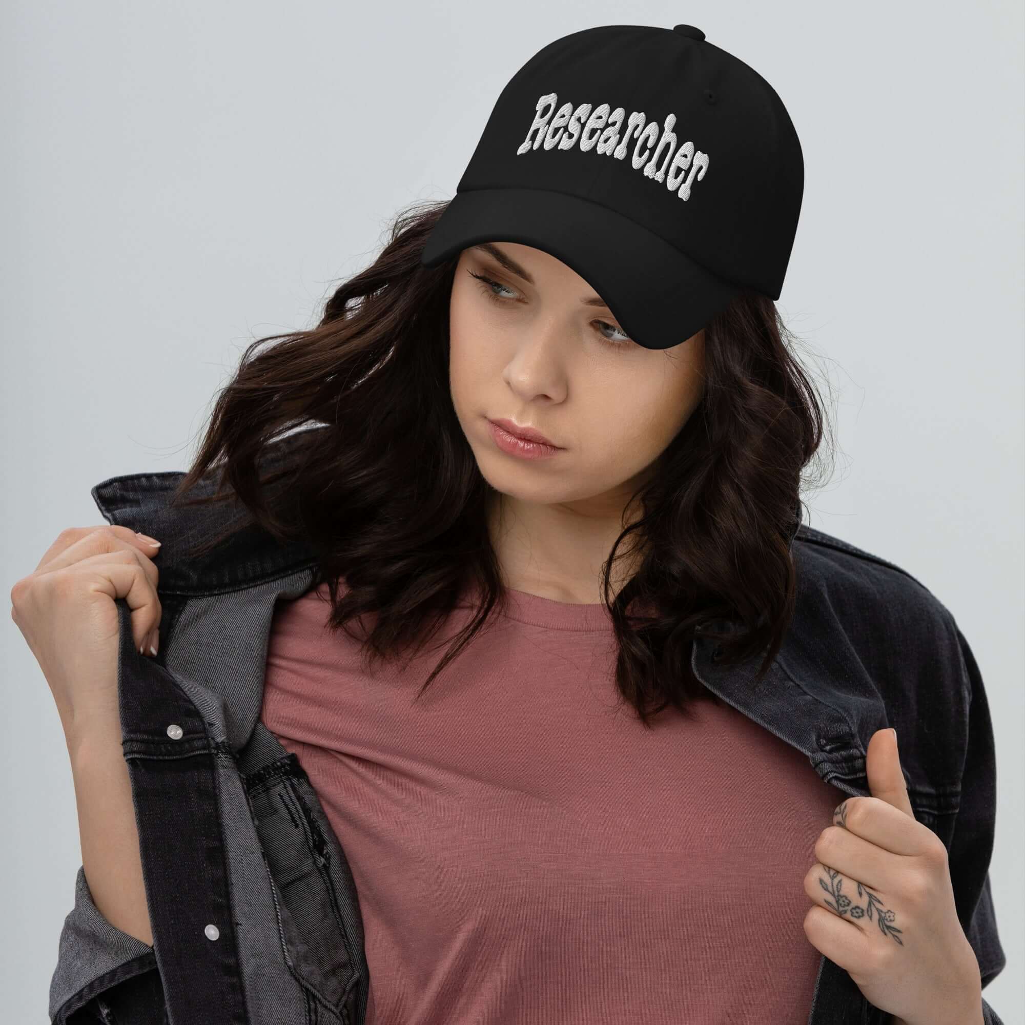 Woman wearing a 'Researcher' baseball cap with casual attire, embodying professional curiosity and style.