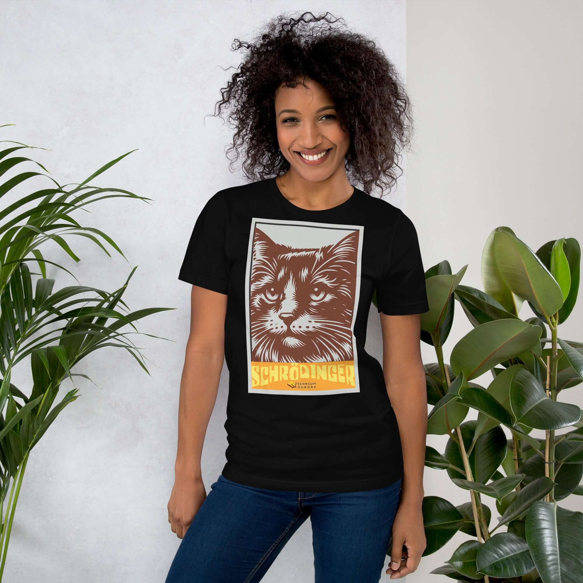 Woman wearing Schrödinger's Cat T-Shirt with a retro cat graphic and plants in the background.