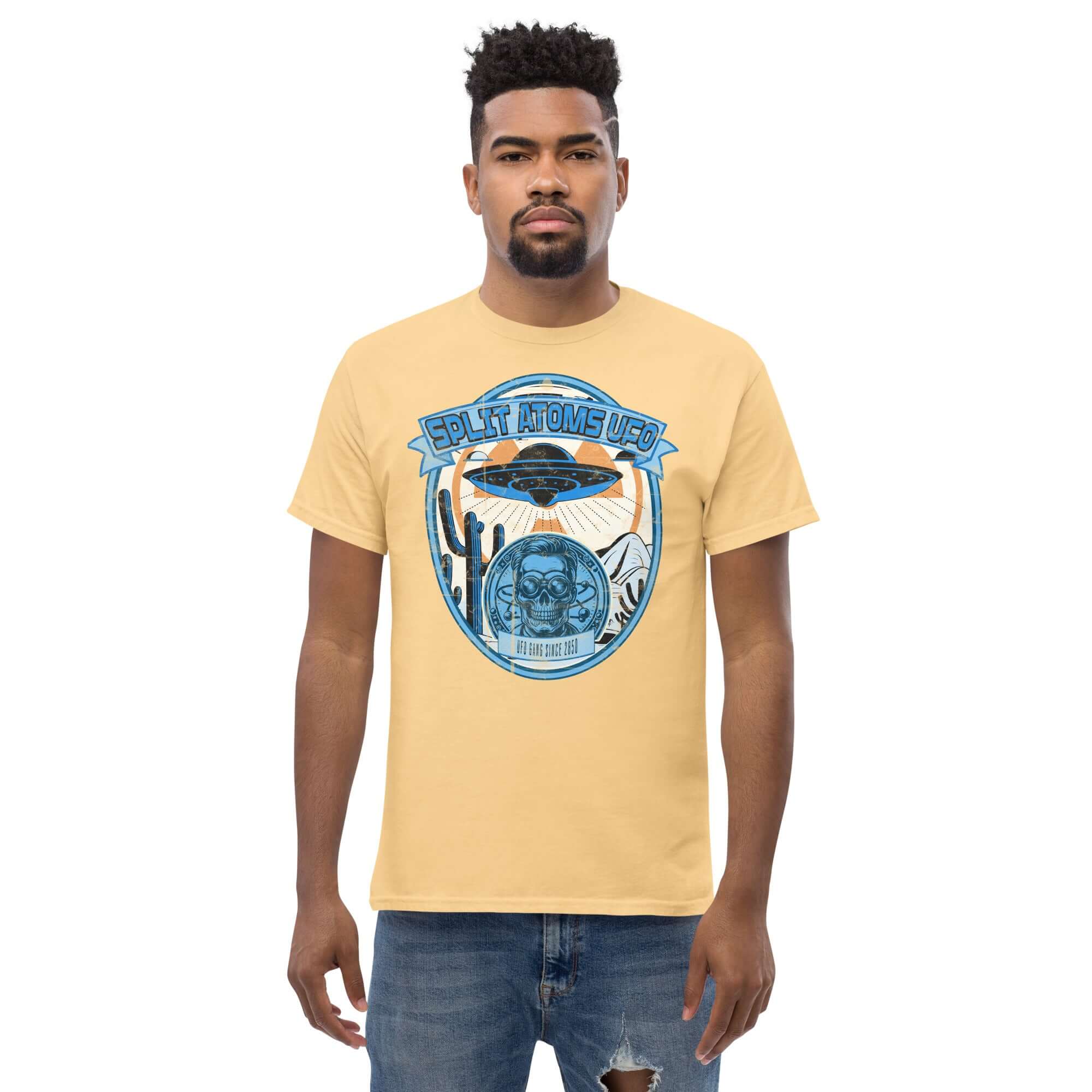 Man wearing Split Atoms UFO Gang T-Shirt featuring retro alien desert design in yellow.