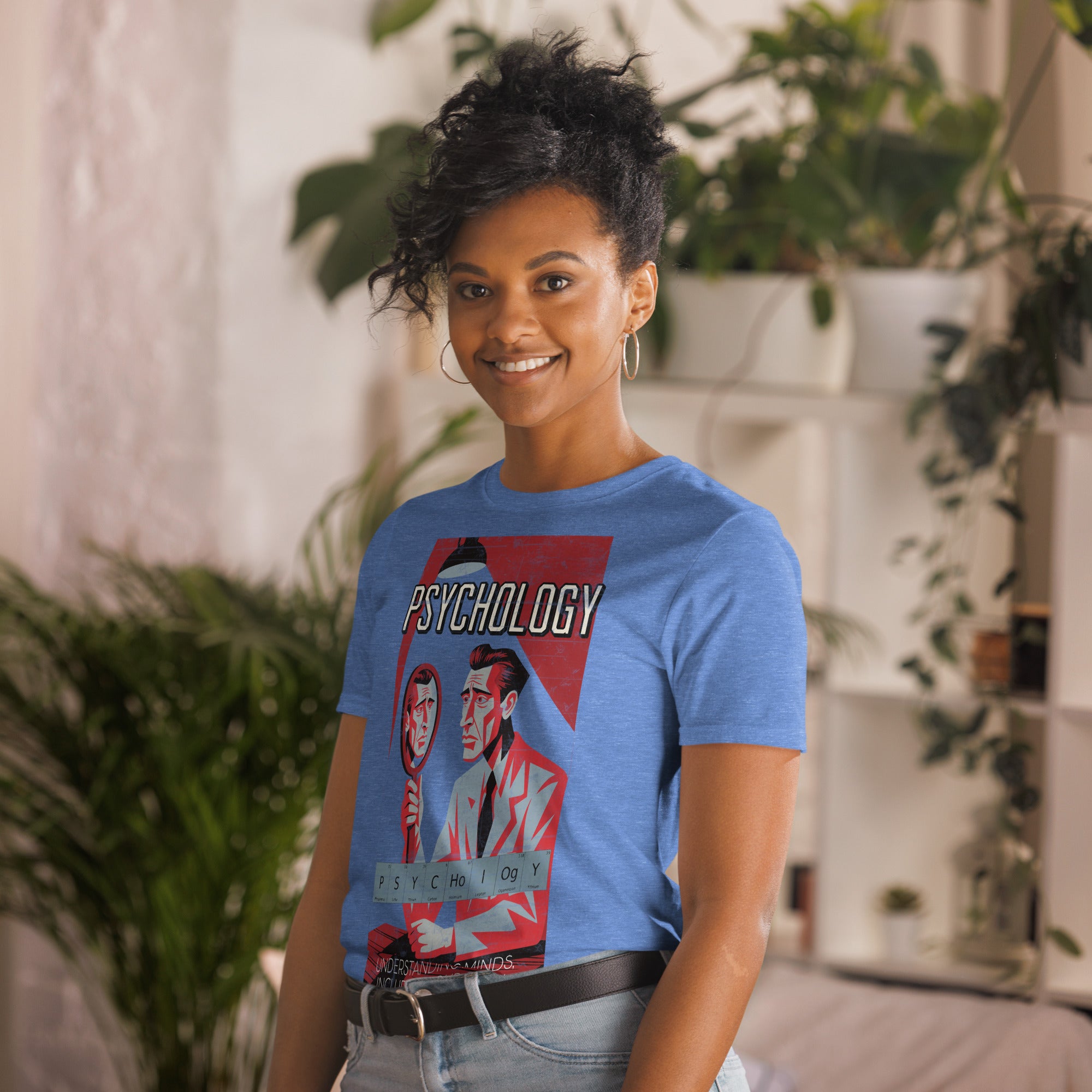 Woman wearing Psychology T-Shirt with vintage lab design, smiling in a cozy room with plants.